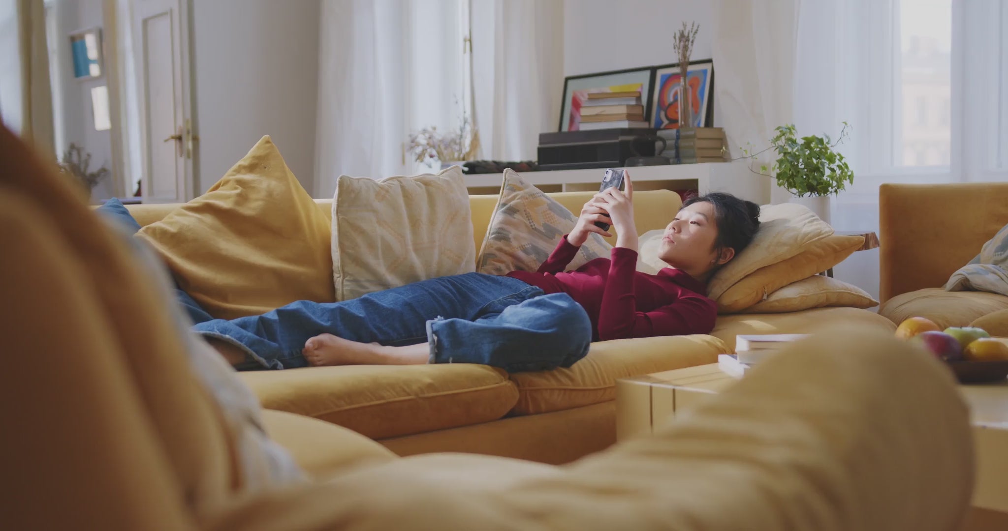 Video laden: Vrouw die ontspannen op de bank ligt met haar telefoon